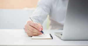 close up of person writing on a notepad