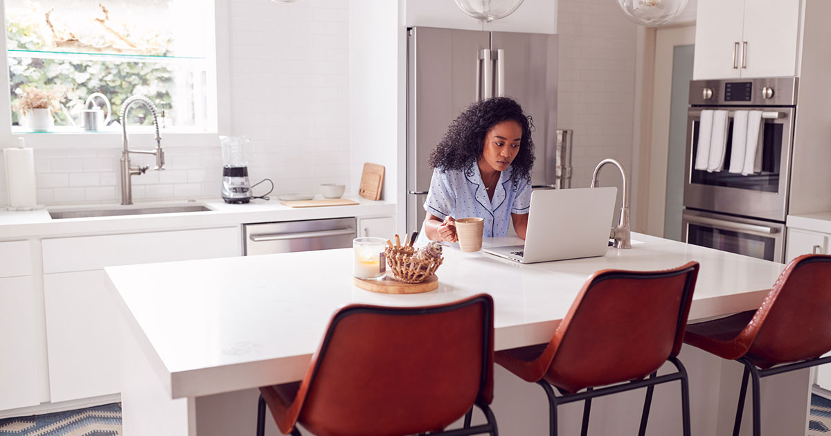 woman at kitchen counter with laptop