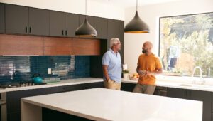 Father and son talking at kitchen counter